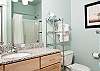Two Luxurious Bathrooms With Granite Counters and Tile Floors