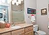 Two Luxurious Bathrooms With Granite Counters and Tile Floors