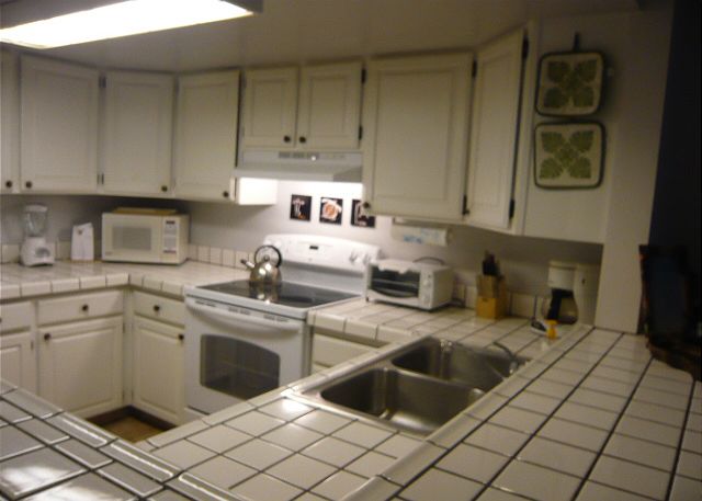 New flat top stove and fridge in this fully equipped kitchen.