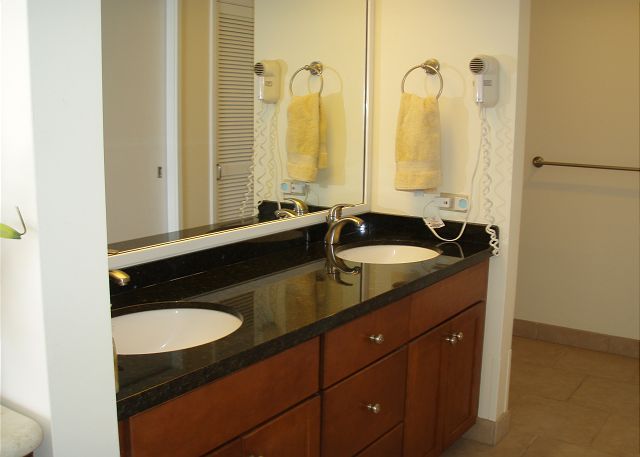 Bathroom with granite, tile, & double sinks.