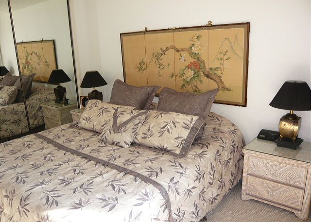 Master bedroom with a king bed and peek-a-boo ocean view.