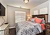 Bedroom 3 is furnished with a Queen Bed, private TV, night stand, dresser, lamp, and includes a walk-in closet.