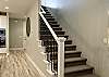 Stairway leading to upstairs entertainment room, patio area, bedrooms and bathrooms.