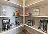 This pantry includes a crock pot, toaster, blender, and coffee maker. 