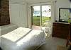 Master bedroom with queen bed, deck and lake view