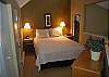 Master bedroom with queen bed and private bath in the upper level loft