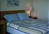 Master bedroom with queen bed, fireplace and lake view
