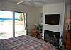 Master bedroom with fireplace, flat screen TV and lakeside deck