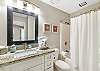 The guest bathroom offers a single vanity, tub/shower combo and is fully stocked with linens for your stay
