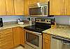 The kitchen offers stainless appliances and includes a built-in microwave, and stove with smooth cooktop.