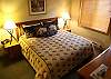 Master bedroom features King bed with luxury bedding and TV.