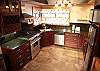 Full kitchen, dishwasher, stainless steel appliances, stone tile flooring.