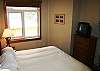 King size bed, upgraded bedding and pillows, and TV