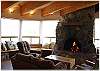 Another view of the living room and stone fireplace with wonderful windows