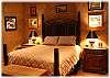 Romantic master bedroom with queen bed, fireplace, private bath, and doors out to the deck
