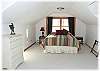 An upstairs loft bedroom has a queen size bed