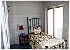 Sunroom on the main floor with two twin beds and door out to the deck