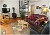 A very comfortable living room with television and a gas "woodstove"