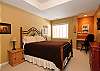 A lower level bedroom with a queen bed