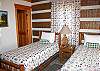 Main level bedroom with two twin beds and a large, private bathroom.