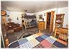 Downstairs bedroom with a queen size bed, bunk bed and a game table