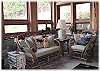 The stone floored sunroom has a fireplace and is great for reading