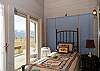 Sun room on the main floor with two twin beds and a door out to the deck