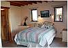 Second bedroom with queen bed and doors to the yard