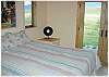 The second bedroom in the main house with a queen size bed and doors out to the yard