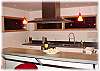 A great kitchen with a huge gas range, stainless steel appliances, and custom concrete countertops