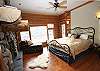 Master bedroom with a rock fireplace