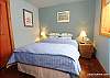 A queen bed in the other lower level bedroom