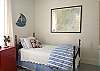 Antique twin beds, dresser and nautical decor in this bedroom. The framed picture is a chart of local waterways.