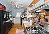 The kitchen is also part of this open floor plan. Fully equipped with a kitchen counter and bar stools in addition to the large family style dining room table.