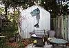 The back yard and garden features two separate seating areas with large unbrellas. The yard is not fenced in, however there's plenty of area to play and relax.