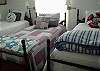 This bright and cheerful bedroom features 3 twin beds. The decor is vintage nautical with red, white and blue bedding, vintage treasures and lots of natural light. Great bedroom!