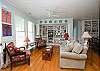 The cottage has a very open layout.  This is the large family room with cable TV and library, dining room and even the kitchen.  There is also a wood burning fireplace. Tall ceilings and lots of natural lighting.