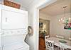 View of dining area and stacking washer/dryer.