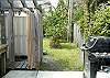 The side door from the kitchen leads out to the gas grill, the outdoor shower with hot and cold water and the fully fenced in back and side yard.