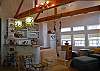 This picture looks towards the open kitchen. Note the beautiful wooden exposed beams in the soaring ceiling!