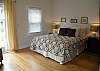 This bedroom features a queen bed, cable TV and a door out to the outdoor deck.