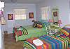 This bedroom features a queen bed and two twin beds