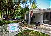 Side yard and deck under the oak tree at Sea Largo cottage.  Sea Largo Cottage has a hammock and a charcoal grill.