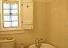 The full bathroom features a claw footed bathtub ( tub only- no shower), stained glass window , beaded board and subway tile.