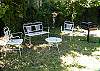 The back yard is fenced in and features a charcoal grill, garden seating and even covered carport/ seating area.