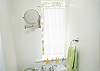 Sunny and cheery Full bath room. The bathroom is in the main cottage and features a shower, toilet and sink. There is also another outsdoor private shower with hot and cold water.
