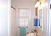 Bright white and cheery this bathroom offers a tub/shower and subway tile flooring.