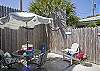 The fully enclosed back yard has a table and chairs ( with umbrella), seating and outdoor art. The outer building in the enclosed backyard/ courtyard also includes the laundry room.