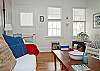This large light filled room includes a sofa, chairs, dining room table and Cable tv.  Full of wonderful nautical details