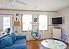 Large, open, bright family room with denim beach-friendly furniture &amp; flatscreen TV.  Fun chair swing!